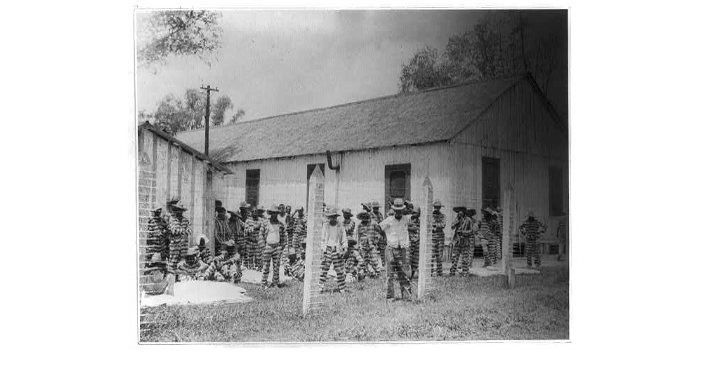 COURTESY OF LIBRARY OF CONGRESS PRINTS AND PHOTOGRAPHS DIVISION. Prison compound No. 1, Angola, Louisiana. Lead Belly (Huddie Ledbetter) in the foreground. Lomax, Alan (Photographer)