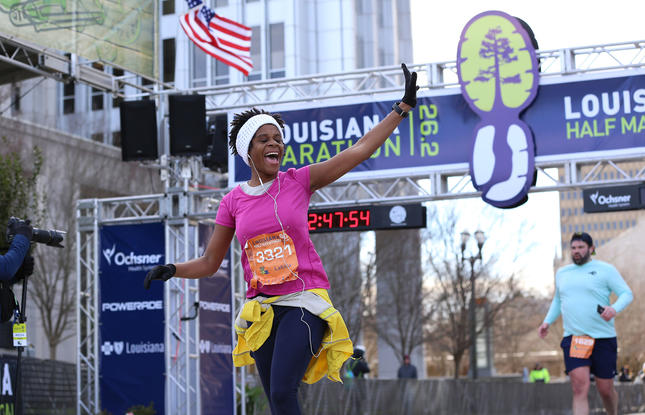 A person runs through the finish line of the Louisiana Marathon.