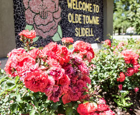 Bright red flowers next to the Olde Towne Slidell mosaic. Credit: Louisiana Northshore