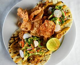 A plate of charred pita bread topped with greens and other vegetables from The Lakehouse. Credit: Louisiana Northshore
