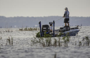 An angler fishes for bass on Toledo Bend in a motor boat.